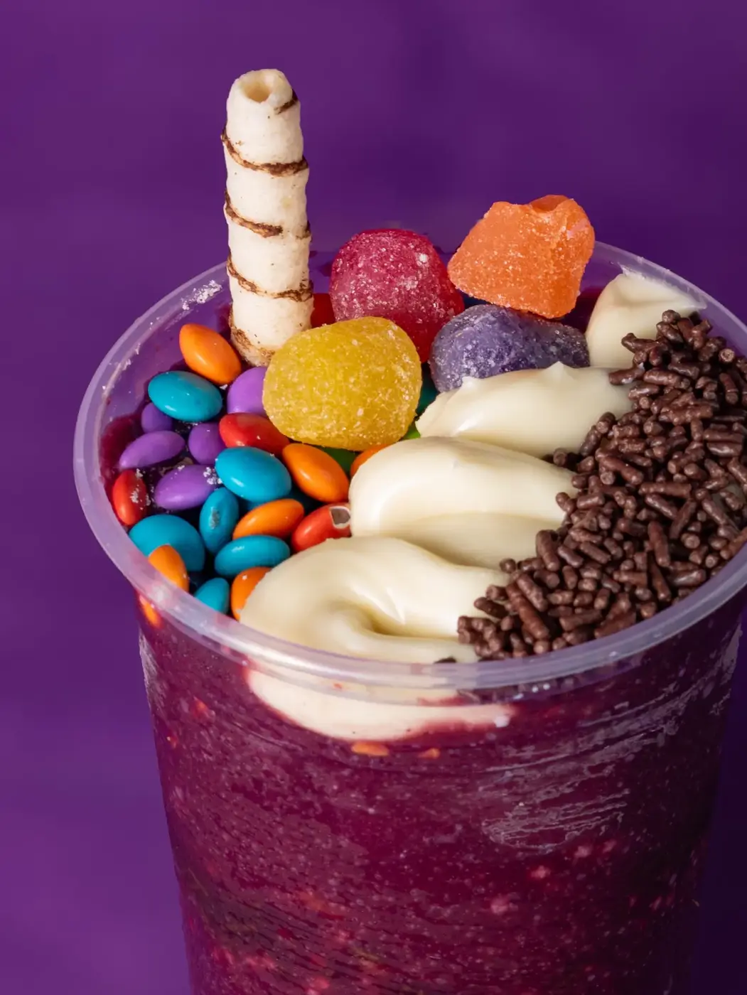 Açaí com confeitos coloridos e canudo de biscoito