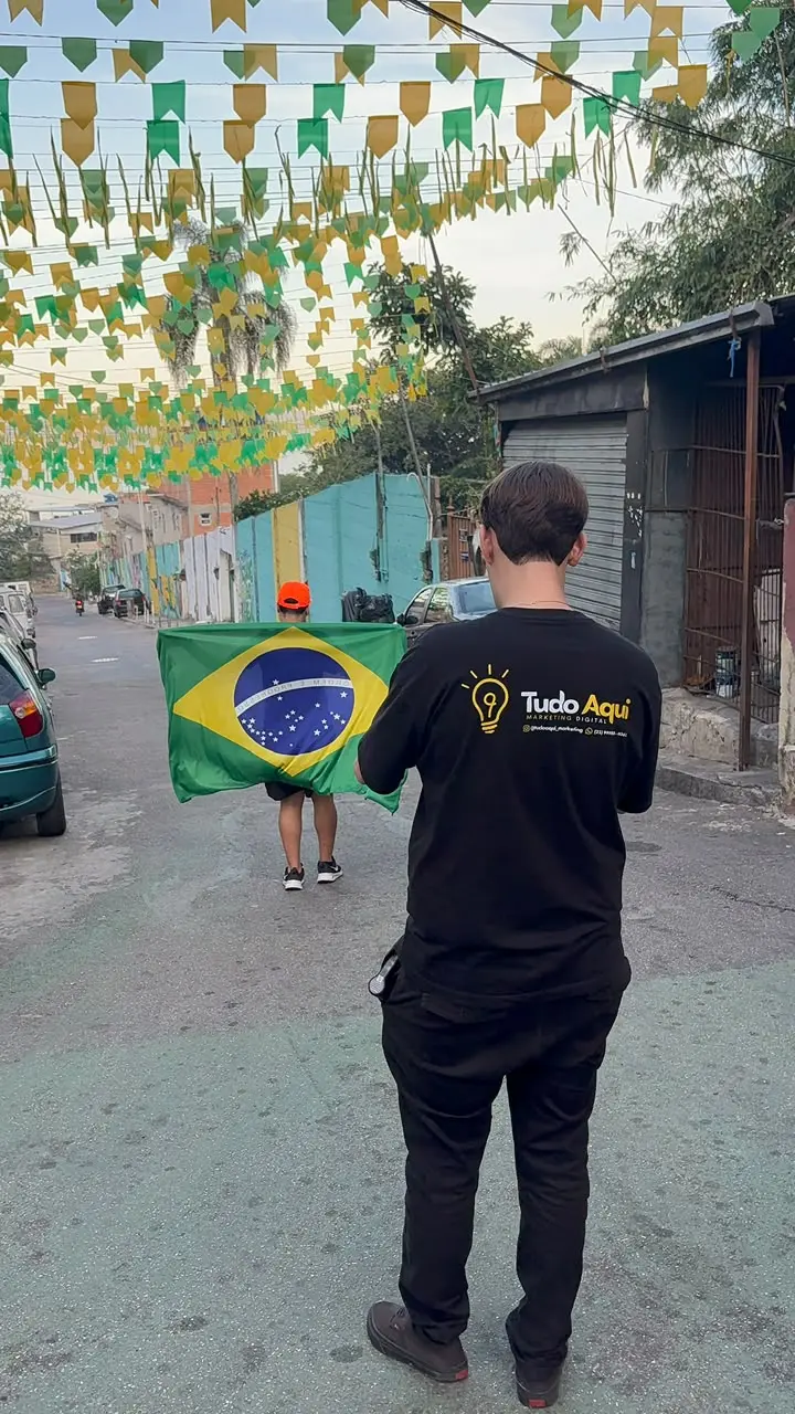 Integrante da Tudo Aqui numa rua enfeitada do bairro