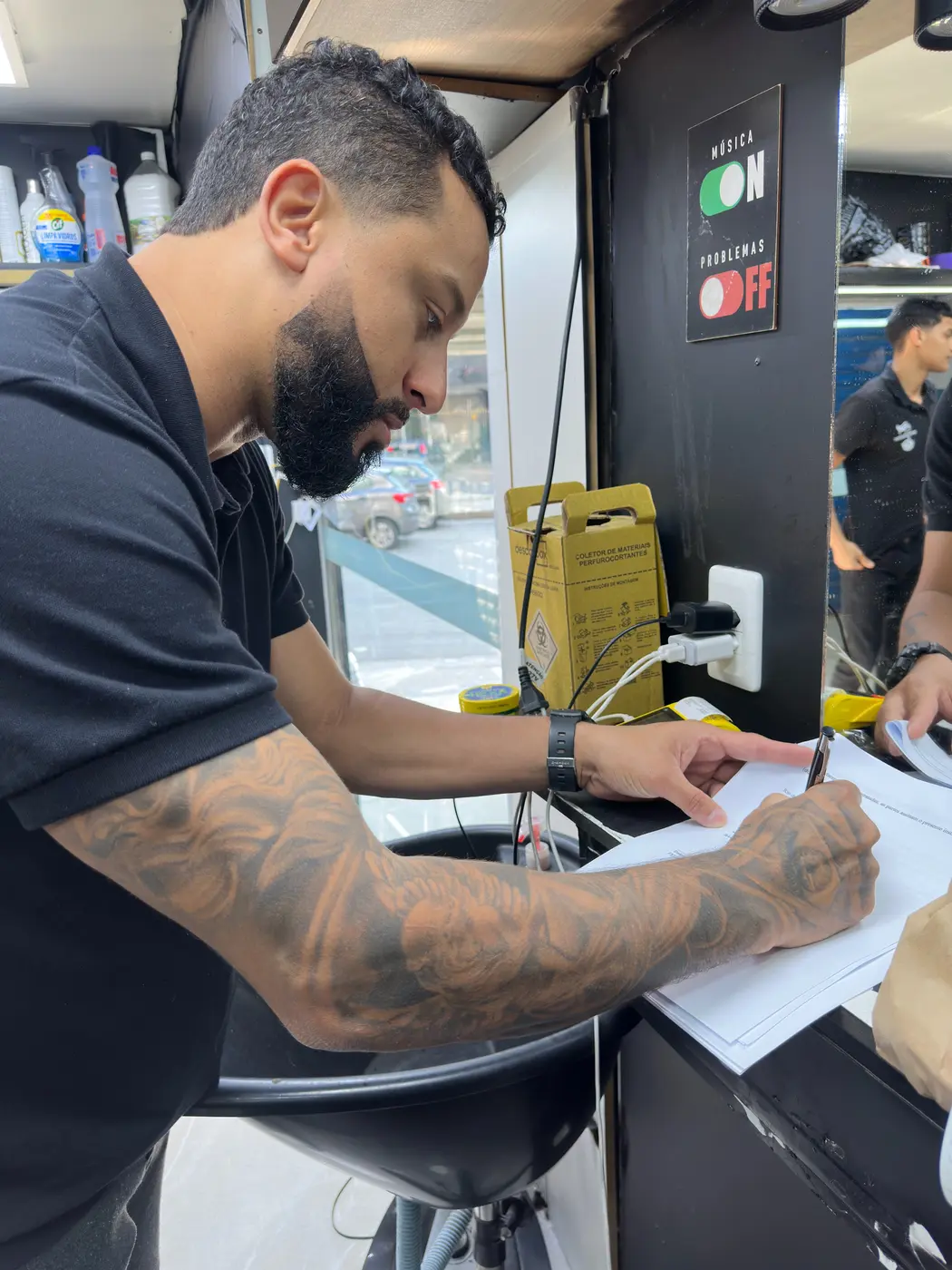 Integrante da Tudo Aqui acertando o planejamento com o dono de uma barbearia